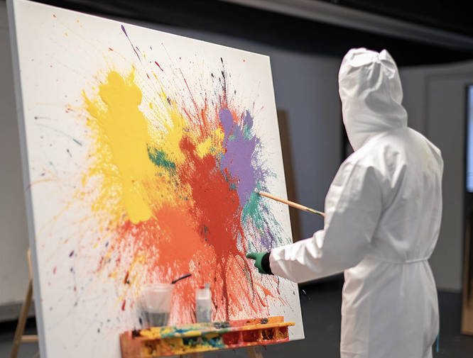 an AI-generated image of a person painting on a canvas splashed with multi-coloured paint at Xtreme Painting