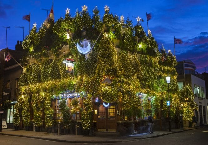 80 Christmas trees and thousands of lights glow on the exterior of The Churchill Arms pub in Kensington, London.
