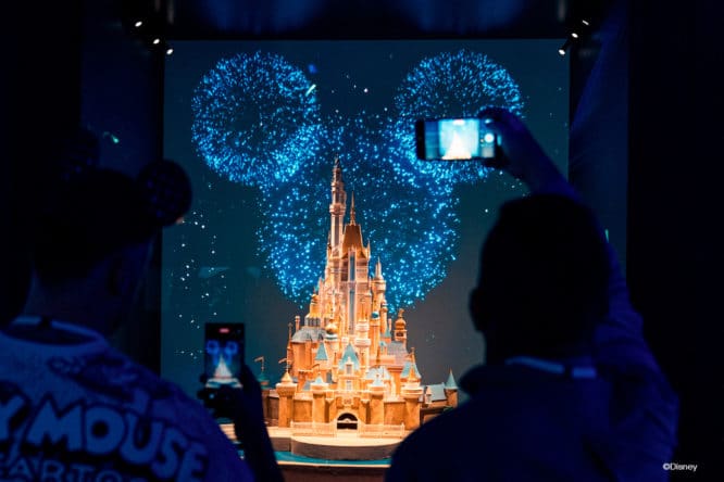 people taking photos of the iconic disney castle at Disney100: The Exhibition. 1 hour plans in London