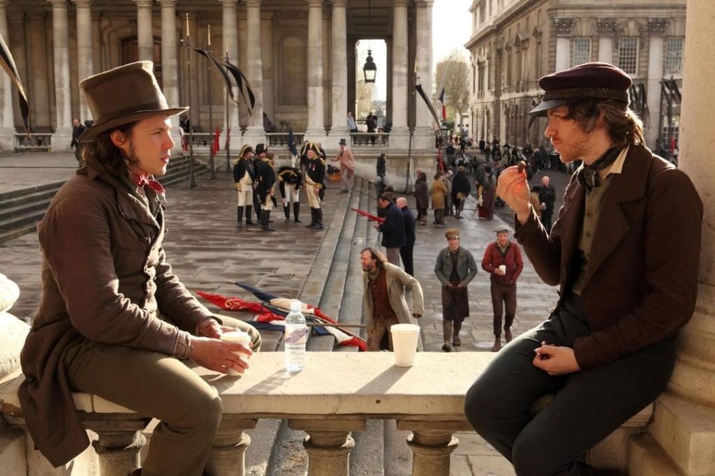 Two men sitting at a bench during the shoot for Les Miserables in London 