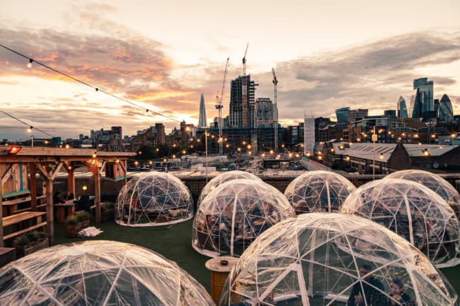 some cosy rooftop igloos in front of a view of London
