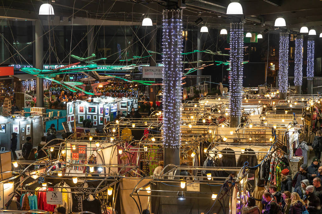 christmas lights strung up across the top of stalls at the spitalfields christmas market